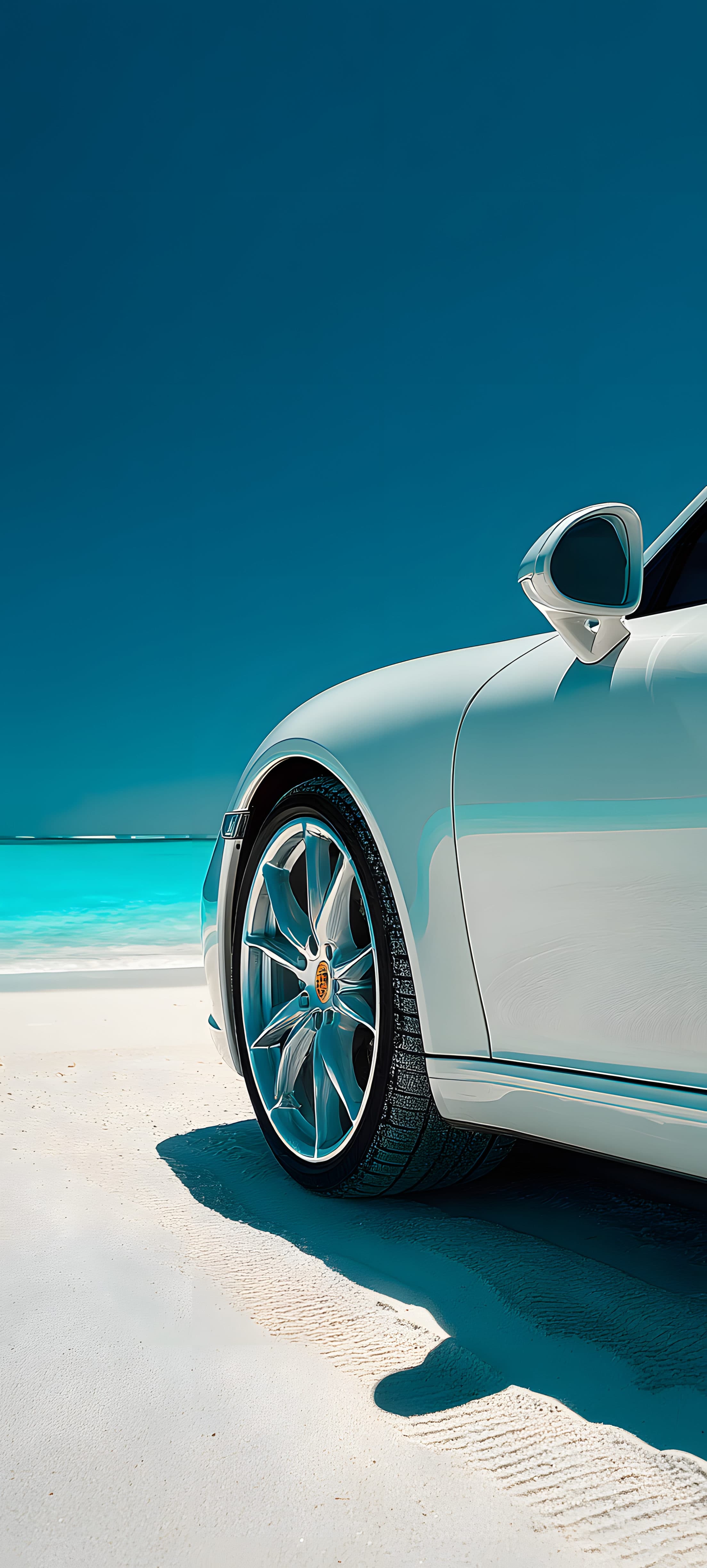 A white luxury car parked on a sandy beach with turquoise ocean water in the background.